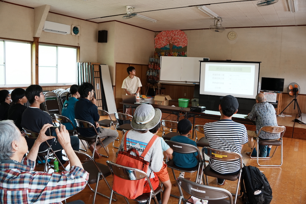 生きもの観察会に先立って、池の概要について植村優人さん(中央奥)から解説があった(安和市民交流会館にて)
