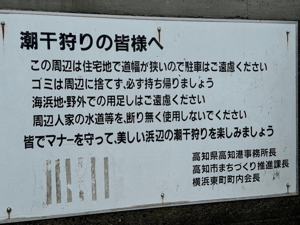 潮干狩りを楽しむ市民も多い。西岸の横浜東町地区の看板。