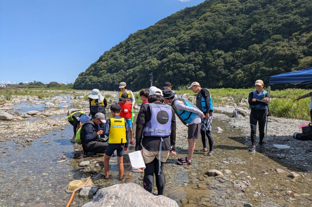 参加したのは小学生と保護者13人。西条自然学校の野口さんから、生きものの見つけ方、つかまえ方を教わる。