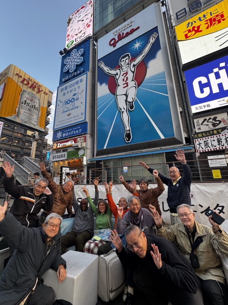 おなじみのグリコの看板前での記念写真。